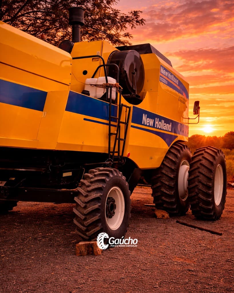 Colheitadeira New Holland TC5090 ao pôr do sol; operações de colheita — Gaúcho Pneus.